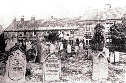 Guisborough Hospital c.1860s A sepia photograph of a row of two storey sandstone cottages.