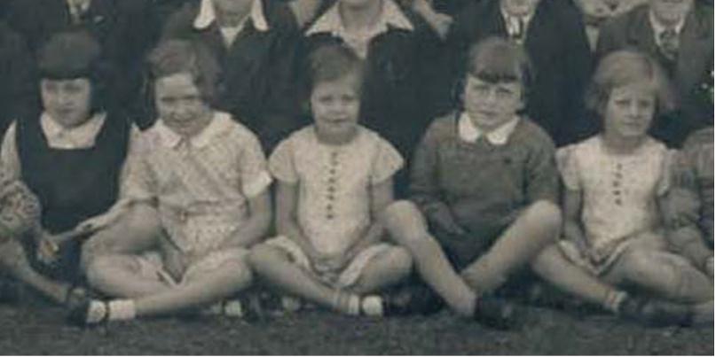 An image cropped from a panoramic whole school formal photograph of 1932, showing girls sitting cross-legged in the front row.